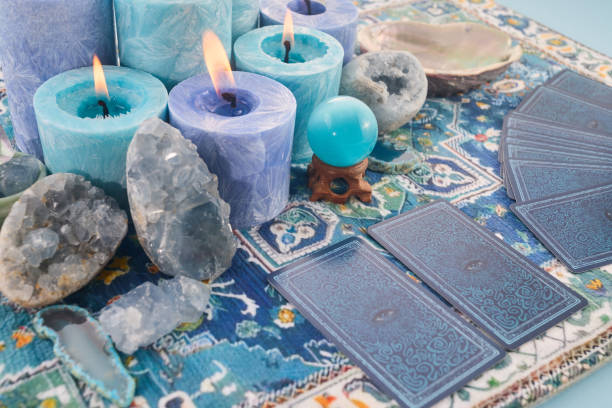 istock Mystical Tarot Setup. Blue candles, crystals, and tarot cards on a patterned cloth. 2190807119