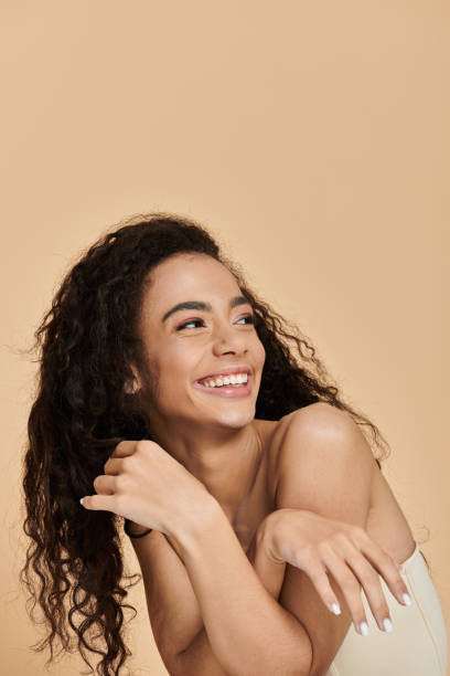 Beautiful young woman smiling with joy against a warm backdrop