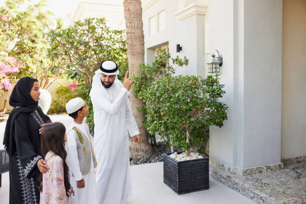 istock Arab man pointing at house while talking with kids 2190807518