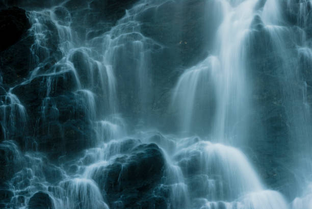 istock Beautiful cascading waterfall surrounded by dark rock formations in a serene natural setting 2190807867