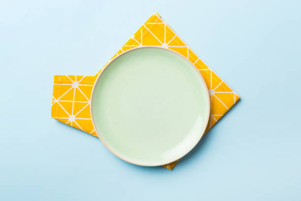 istock Top view on colored background empty round green plate on tablecloth for food. Empty dish on napkin with space for your design 2190808420