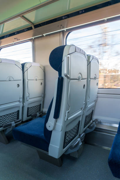 istock Rows of comfortable, soft seats in a modern train with blue fabric upholstery are arranged along the aisle. The shot emphasizes the comfort and advanced technology of modern transportation. 2190809419