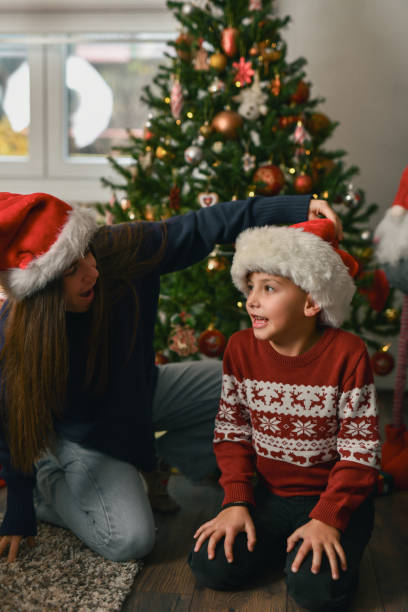 istock Mother Teasing Cute Son Playing With His Santa Hat And Smiling 2190809600