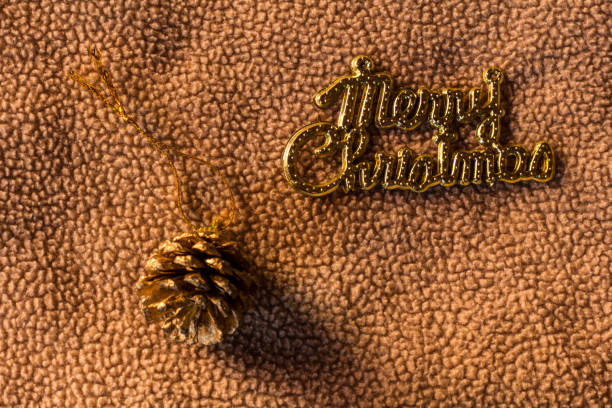 Golden christmas cone on holiday lights background. New year greeting card with ball and blured illuminated background. Copy space for text