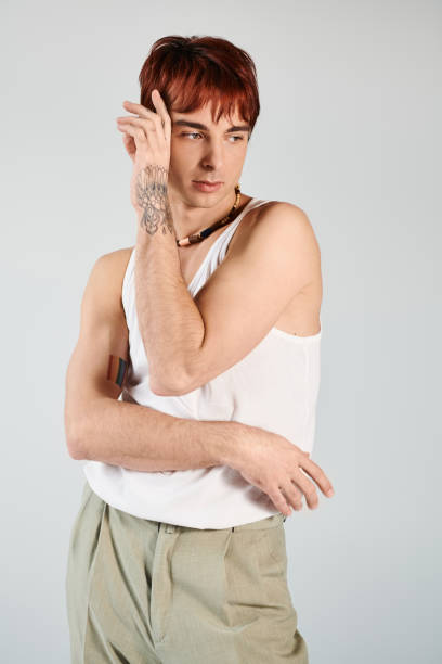 istock Young man showcasing modern fashion style in a minimalist studio setting 2190825463