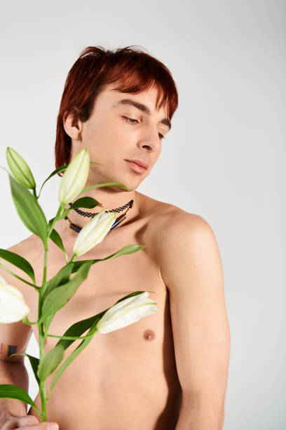 istock Young man showcasing unique fashion style with flowers in a creative setting 2190825820