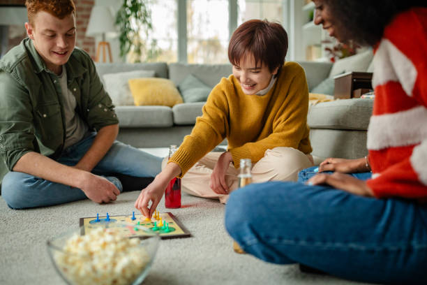 istock Group of friends enjoy board game on carpeted floor. 2190829985