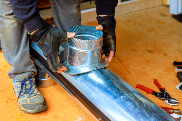 istock Worker attaching a metal duct fitting on a ventilation system during a home improvement project in a workshop 2190833470