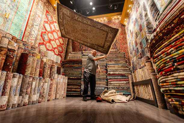 istock Man tossing plush rug in an elegant carpet showroom 2190835529