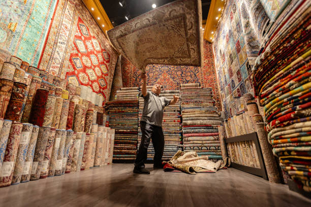 istock Man displaying a rug in vibrant carpet store scene 2190835547