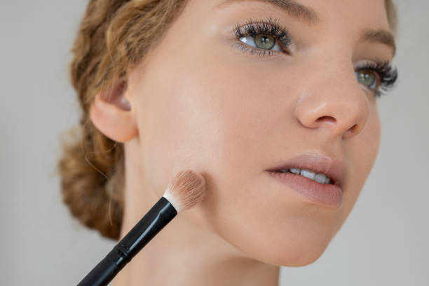 istock Woman applying makeup with brush 2190835565