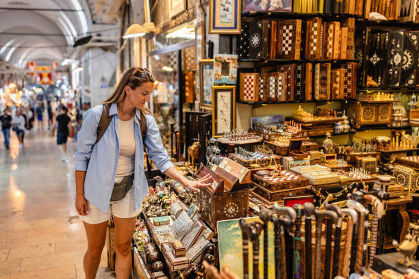 istock Shopper examines intricate chess sets at market stall. 2190836148