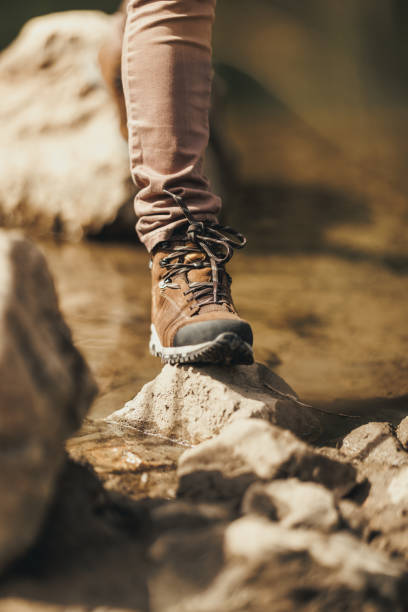 istock Woman With Hiking Boot Walks On Rocks At Mountain River 2190837735