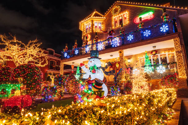 New York City, USA, December 4, 2024:  A dazzling Christmas light display covering a house and yard at nighttime, showcasing decorations like snowflakes, wreaths, and a cheerful snowman, epitomizing holiday celebration and festive spirit.