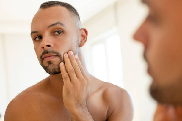 istock Male looking at his face in front of mirror 2190841644