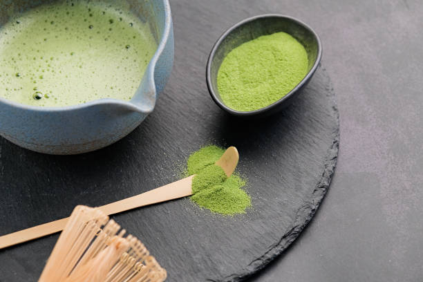 istock Traditional green matcha kit, Bamboo whisk and beverage on slate plate , dark background with copy space 2190843165