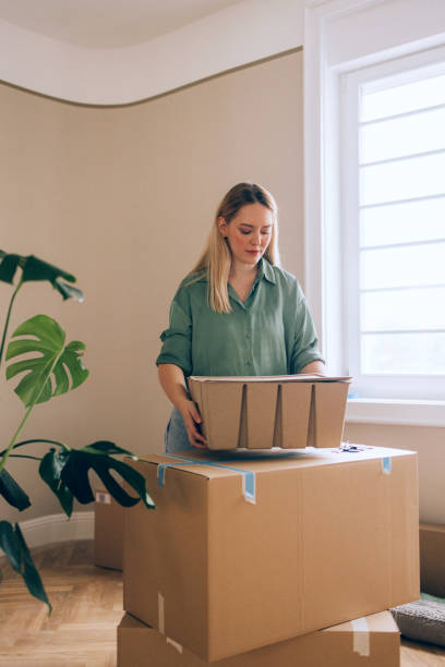 istock Young Woman Packing Boxes at Home During a Moving Process 2190846949