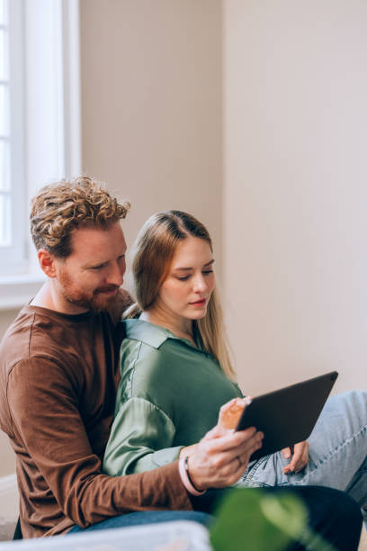istock Young Couple Using a Tablet Together in a Cozy Home Setting 2190846968