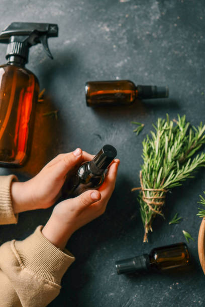 istock Amber glass spray bottle with a black cap placed on a dark rustic surface, surrounded by rosemary sprigs and natural decor elements. Concept of natural, eco-friendly cosmetics or aromatherapy products 2190851310