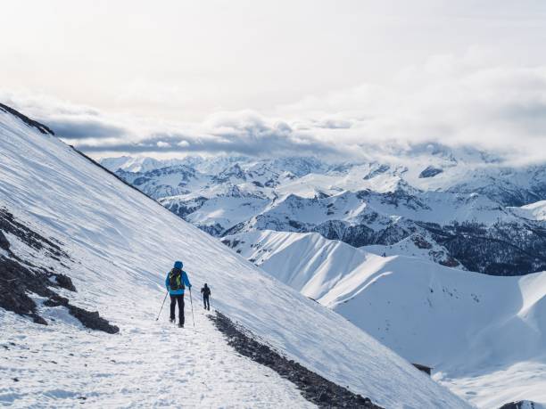 istock Two hikers trekking in snowy mountain landscape 2190853546