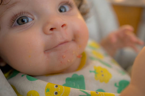 istock Close-Up of a Baby's Happy Face During Mealtime 2190855706