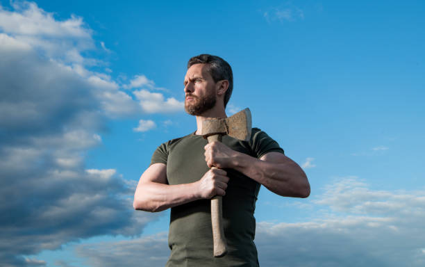 strong man with axe. caucasian man hold ax. strong man on sky background.