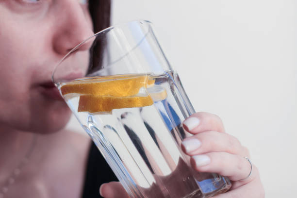 istock A young woman drinks water with lemon from a transparent glass 2190857903