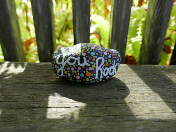 istock Sunlight coming through wooden bars with kindness rock 2190861498