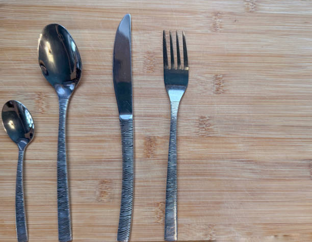 istock Fork, knife and spoon on a wooden board 2190863276