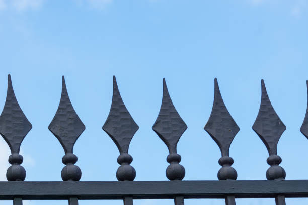istock Metal fence with sharp diamond-shaped spikes against a blue sky 2190875727