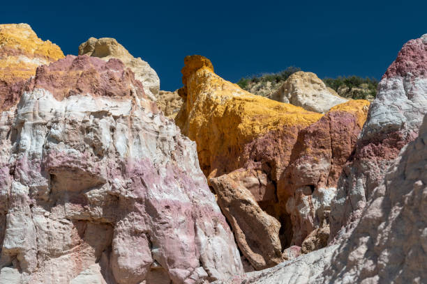 istock Colorful rock formations in a rugged terrain with sandy cliffs illuminated by bright sunlight during midday in a vibrant desert landscape 2190876546