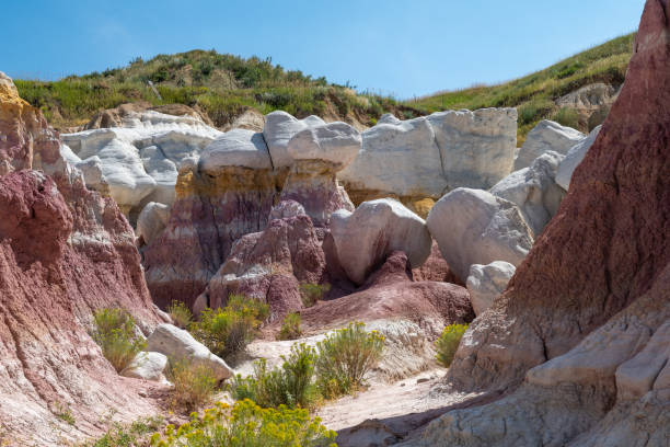 istock Colorful rock formations blend with greenery in a scenic valley under a clear blue sky, showcasing nature's vibrant hues during a sunny day 2190876729