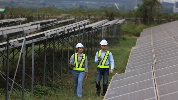 istock The solar farm(solar panel) with two engineers walk to check the operation of the system 2190877021