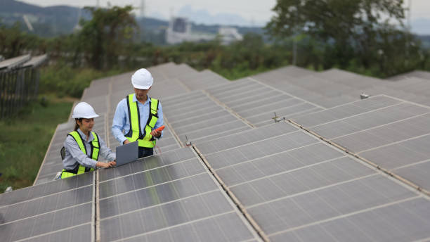 istock The solar farm(solar panel) with two engineers walk to check the operation of the system 2190877023