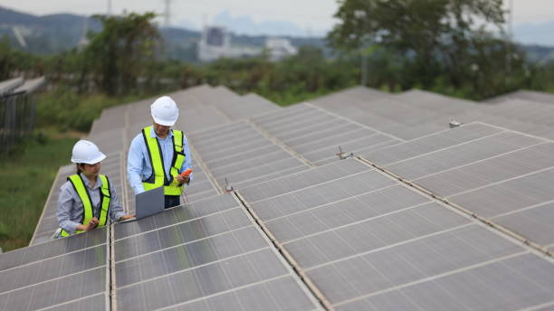 istock The solar farm(solar panel) with two engineers walk to check the operation of the system 2190877027