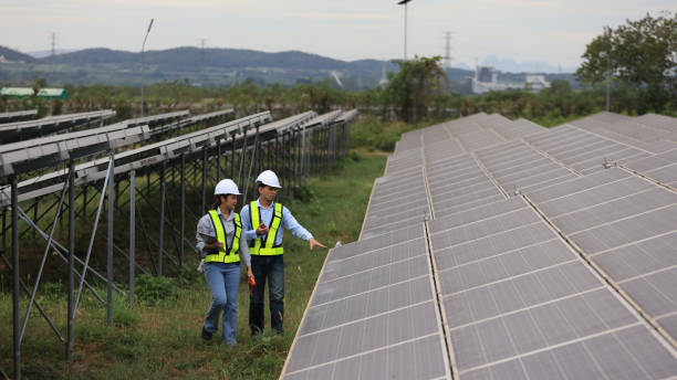 istock The solar farm(solar panel) with two engineers walk to check the operation of the system 2190877030
