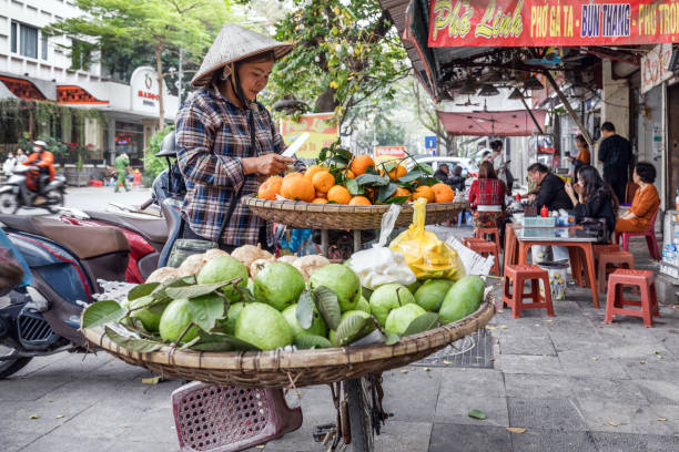 Hanoi, Vietnam - March 22, 2024: A Vietnamese woman sells fruit on the street on the Weekend Walking Street in Hanoi
