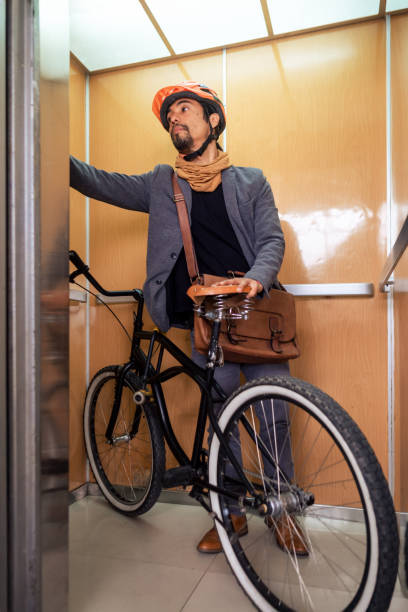 istock Vertical image of a businessman with his bicycle inside an elevator pressing the button. 2190881815