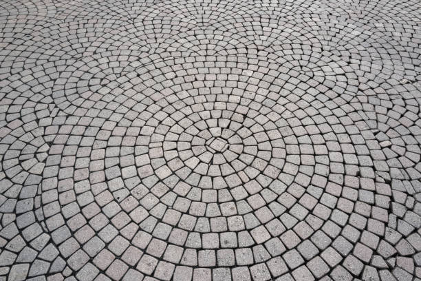 Stone road texture. Stone walk background. Granite cobblestoned pavement background. Rough brick road. Side walk. Stone cladding pavement