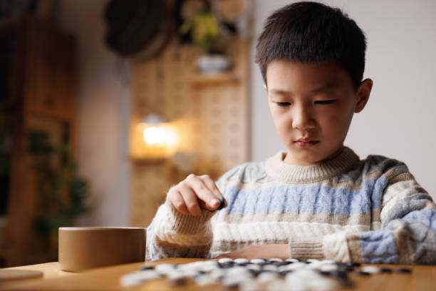 istock one china boy is playing Go - Board Game at home 2190883798