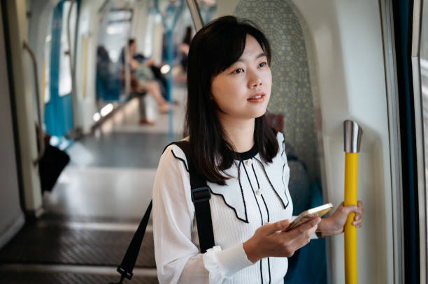 istock Asian businesswoman using smartphone while riding in the subway train 2190884358