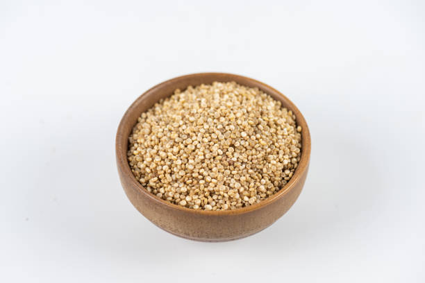 Yellow quinoa in wooden bowl on white background