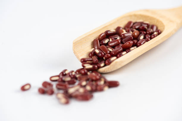 istock Red beans in wooden spoon on white background 2190884972