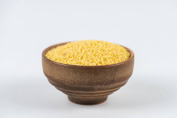 Yellow millet in bowl on white background
