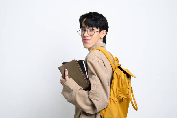 istock Happy college student with glasses and backpack and holding books on white background. Educational and back to school concept 2190885742