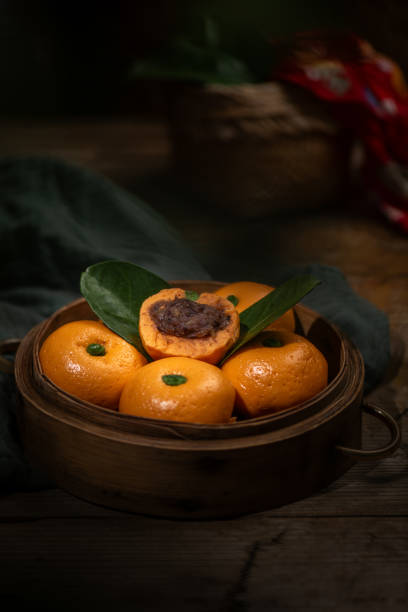 Orange shaped buns in a steamer on a dark background
