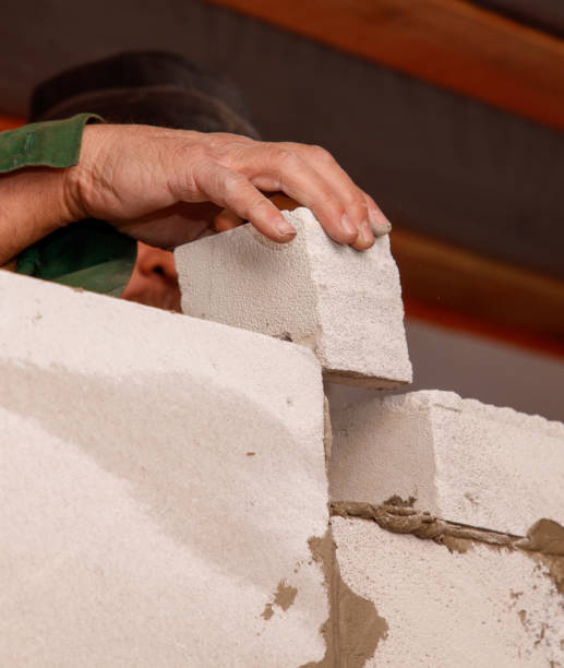 istock A man is laying a brick on a wall 2190895318