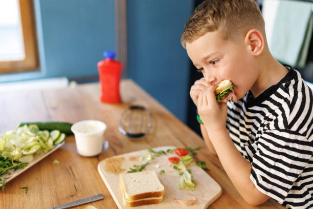 istock Boy eating sandwich in the kitchen 2190896337
