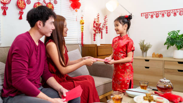 istock A child joyfully receives a red envelope (angpao) from parents during a Chinese New Year celebration, symbolizing blessings and good fortune 2190899470