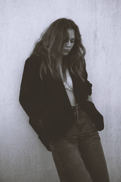 istock Beautiful Young Woman Leaning Against a Grey Wall 2190903334